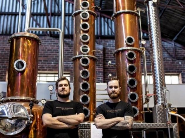 two men standing in front of distilling