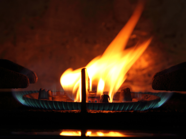 Close-up photo of a gas burner with an orange flame