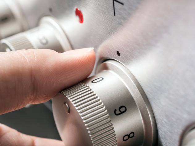 Close-up photo of a hand adjusting a stove hob to zero.