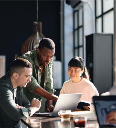 Group of people sitting at a table working on laptops