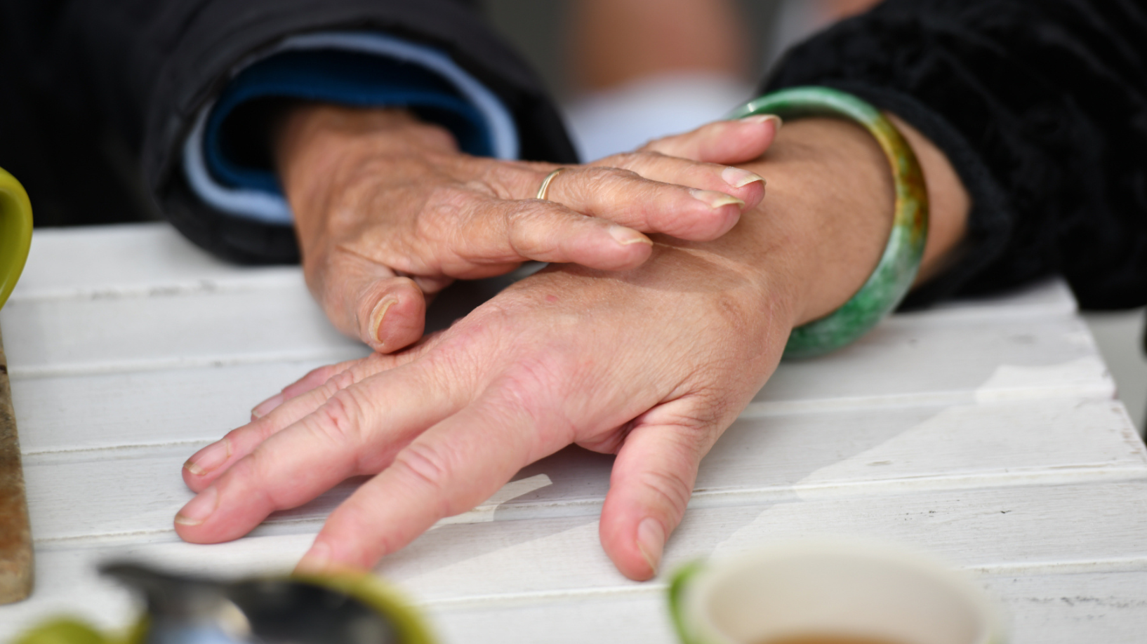 Close-up photo of two hands, one is reaching out to touch the other.