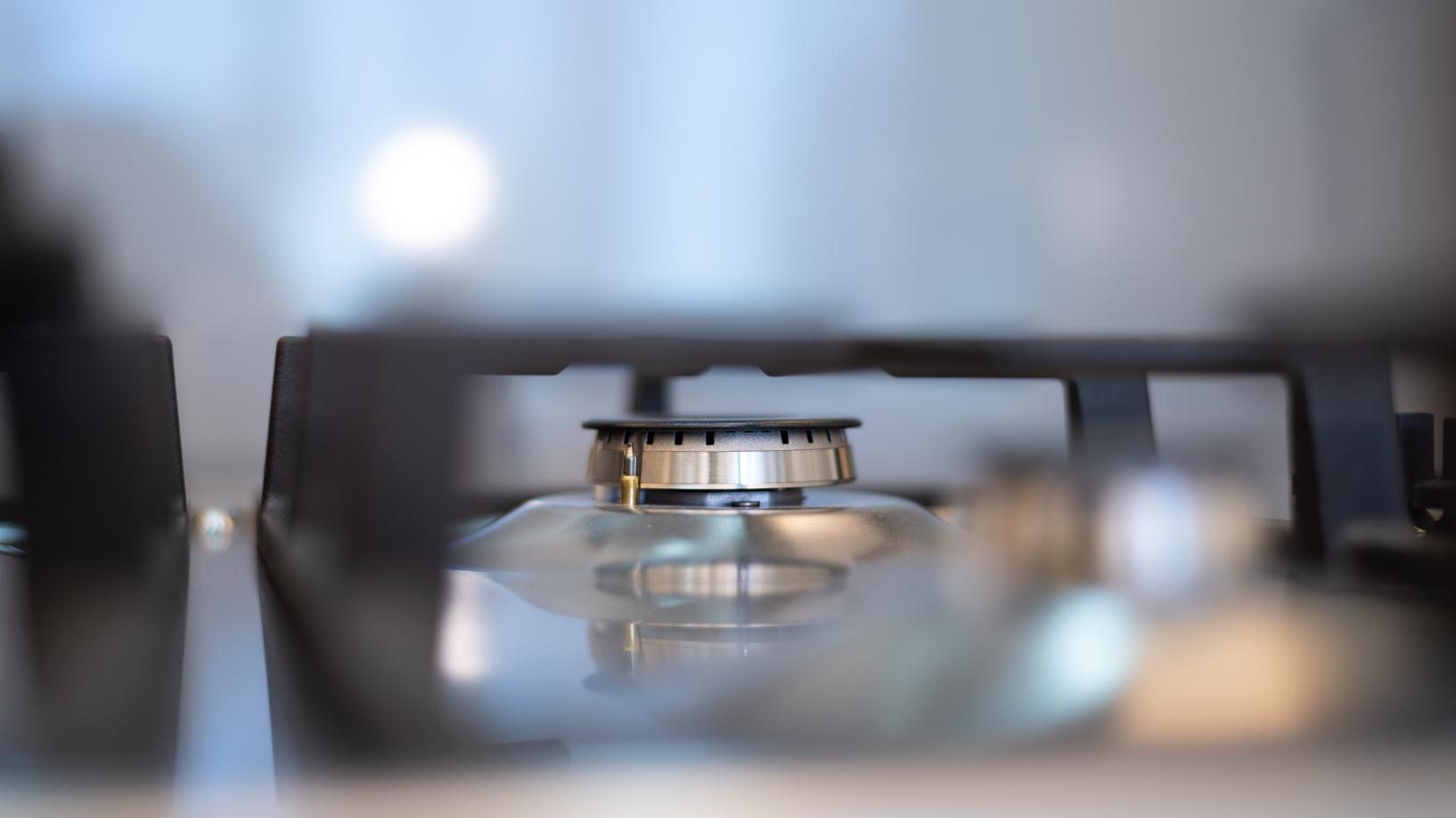 Photo of a gas burner on a stovetop, in focus.