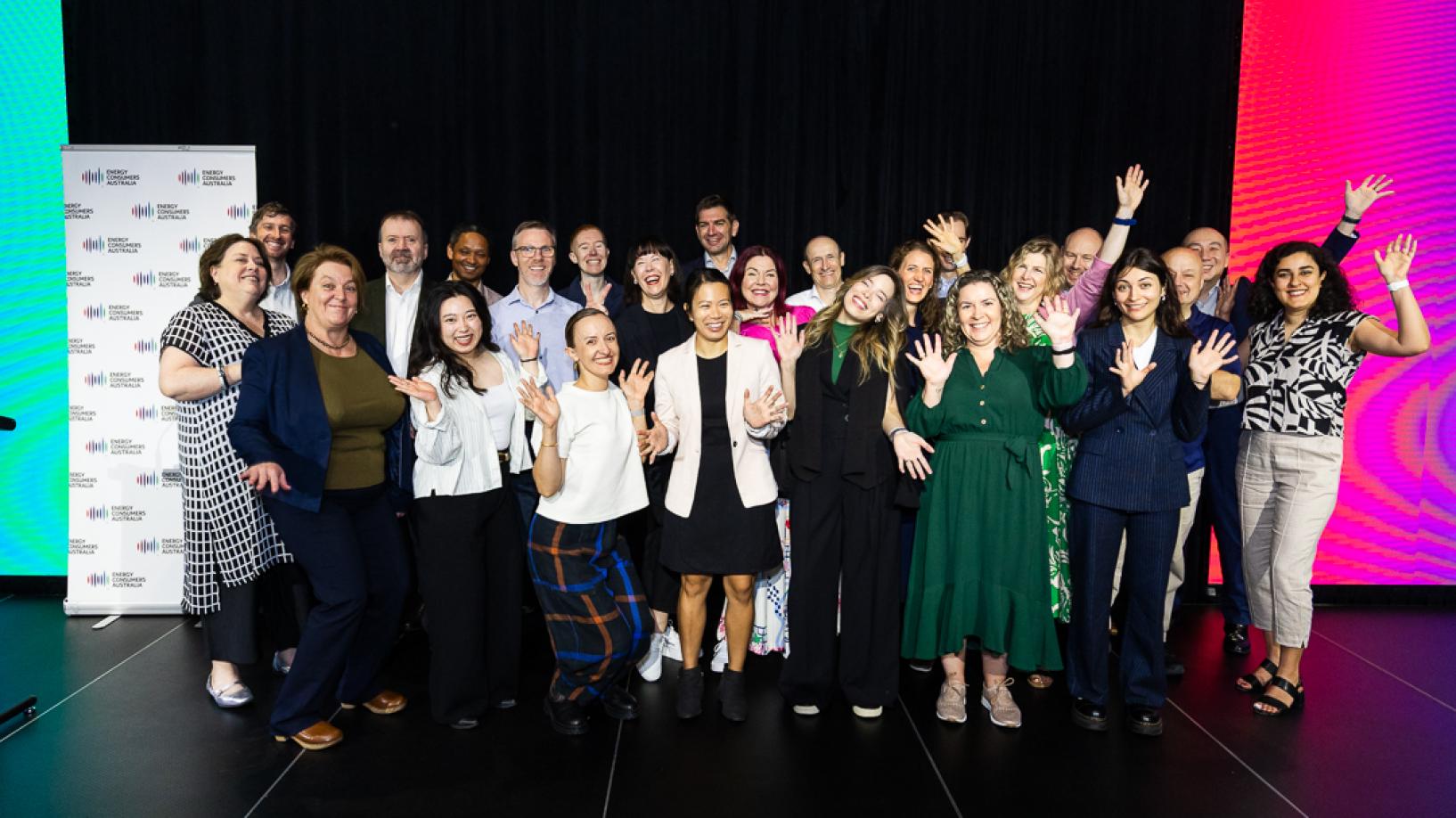 Photo of the ECA team at Foresighting Forum 2026. The team is standing on stage in front of a black curtain, waving and smiling.
