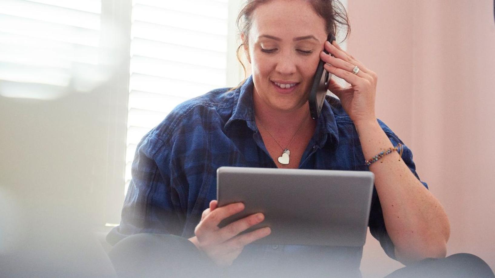 Photo of person on phone looking at bill