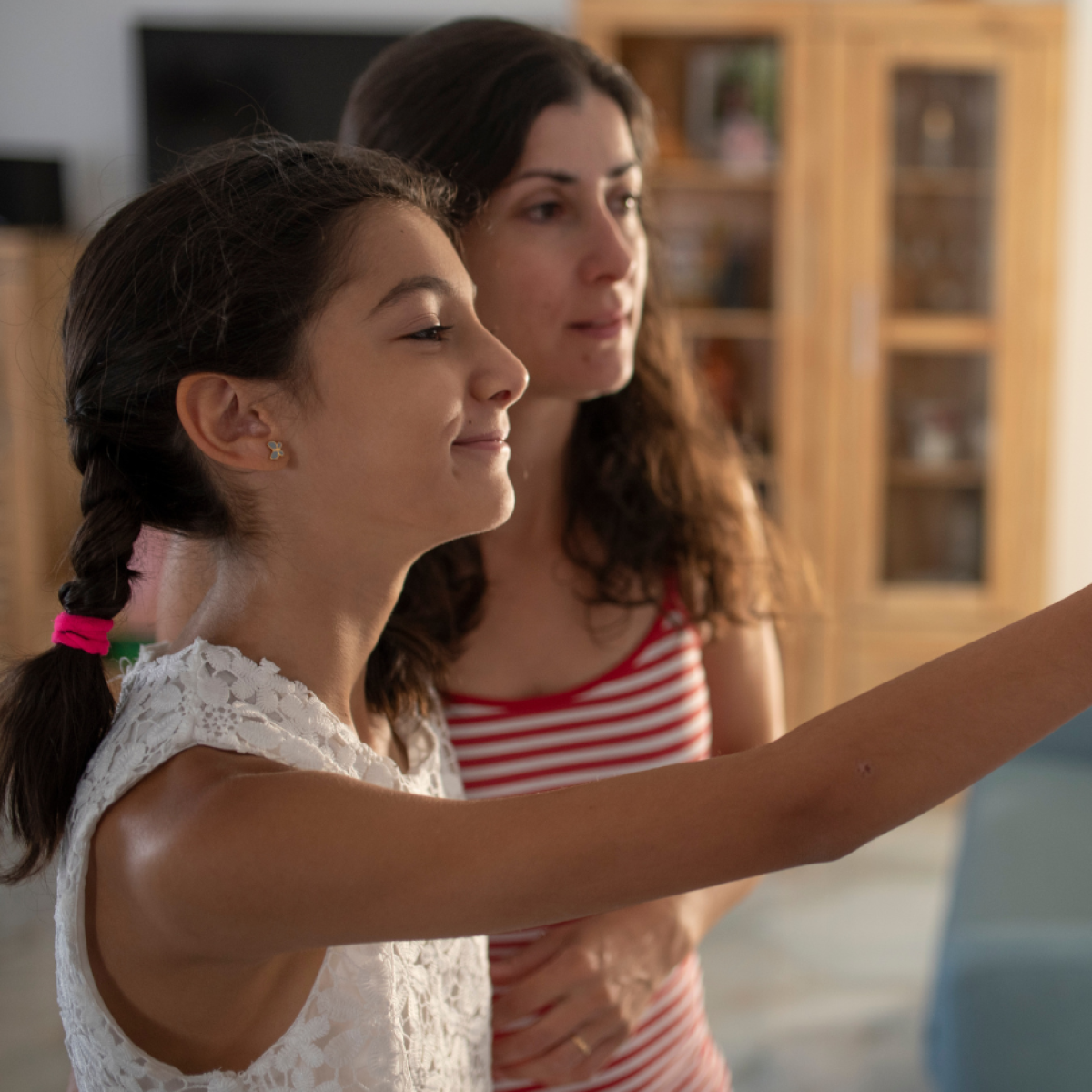 Photo of two people using a thermostat in a home interior