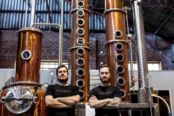 two men standing in front of distilling