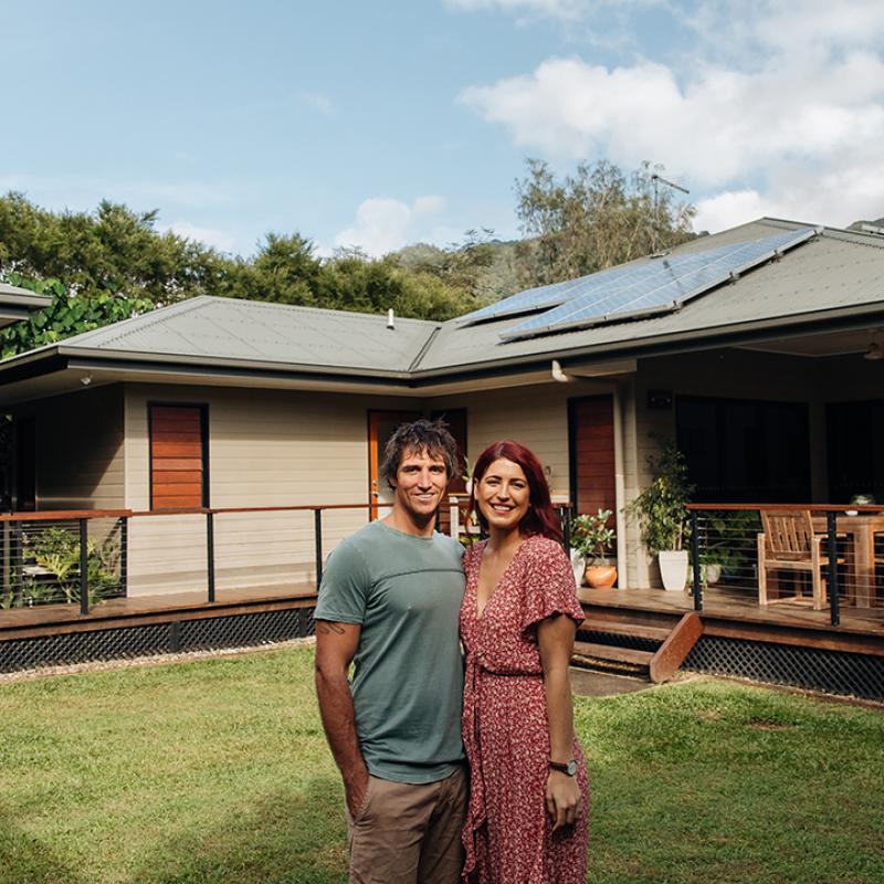 Couple standing in front of home with solar panels