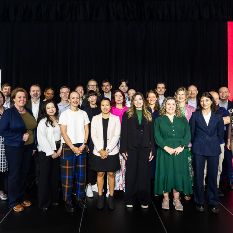 Photo of the ECA team at Foresighting Forum 2026. The team is standing on stage in front of a black curtain, smiling.