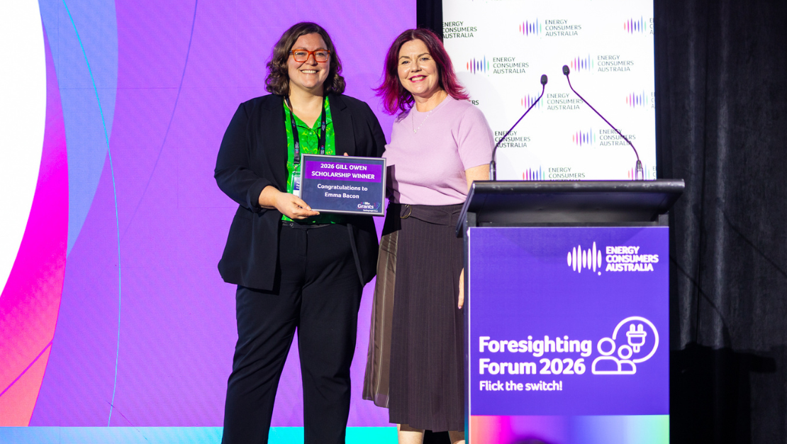 Photo of the 2026 Gill Owen Scholar, Emma Bacon, with ECA's Alex Bishop, standing on stage and smiling at the 2026 Foresighting Forum.