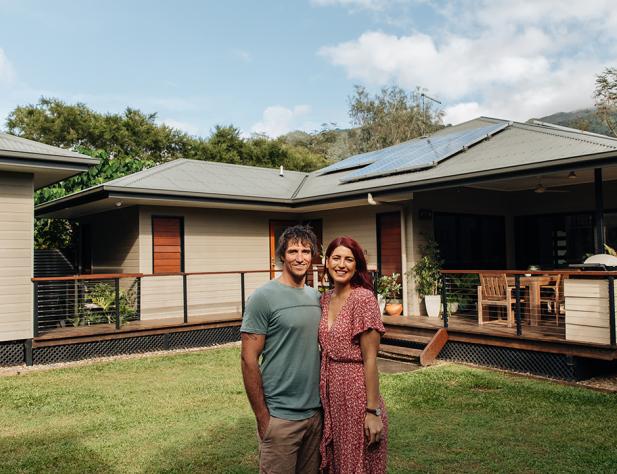 Couple standing in front of home with solar panels