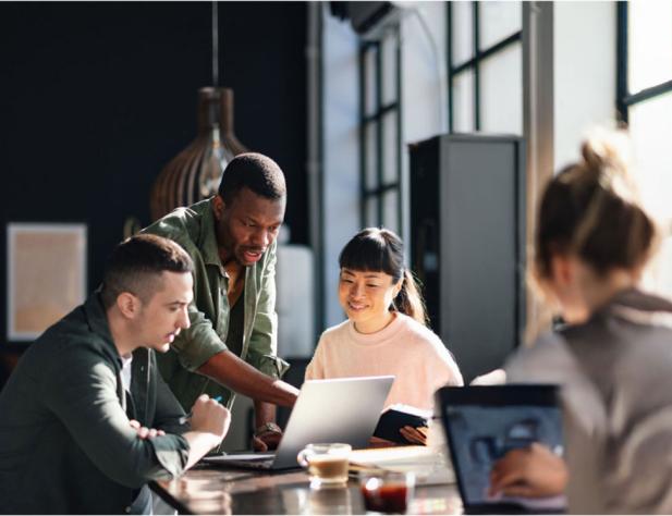 Group of people sitting at a table working on laptops