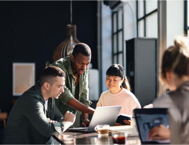 Group of people sitting at a table working on laptops