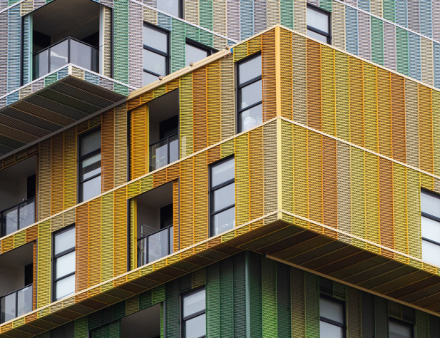 Photo of a colourful apartment building with lots of windows.