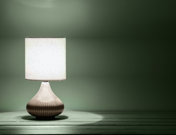 Photo of a table lamp illuminating a green-coloured room