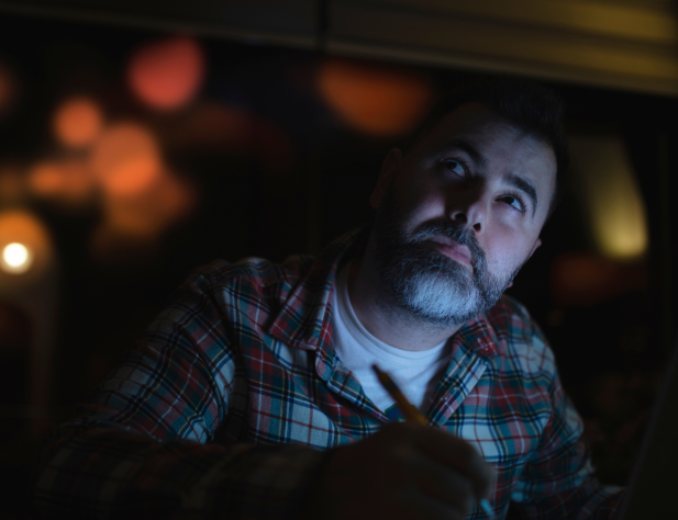 Photo of a person in darkness with their face illuminated