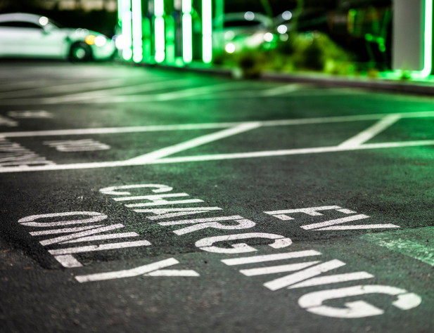 Photo of a parking spot for an electric vehicle with painted sign, 'EV Charging Only'.