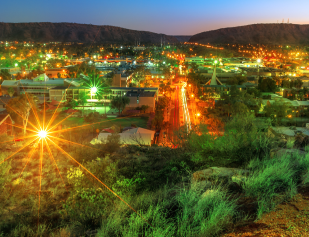 Photo of Alice Springs streetscape with bright shining lights at dusk or dawn