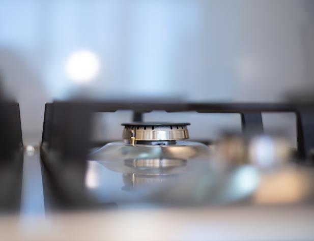 Photo of a gas burner on a stovetop, in focus.