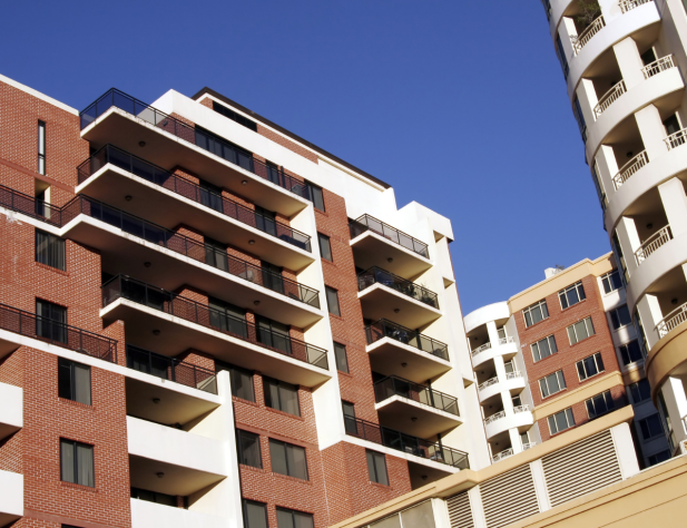 Photo of apartment buildings with blue sky in the background.