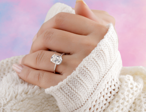 Photo of a pair of hands in a cream coloured jumper with a rainbow background