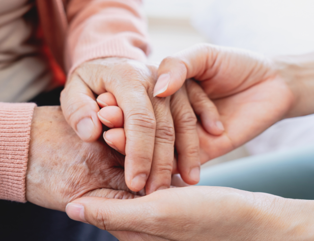 Close-up photo of two pairs of hands holding one another