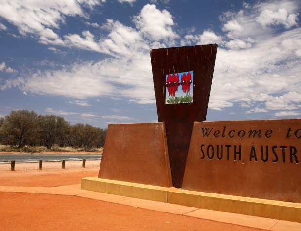 Photo of a sign featuring a picture of Sturt's desert pea and the words Welcome to South Australia.