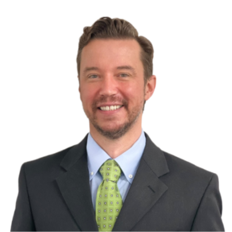 Photo of a person smiling at the camera, wearing a dark grey suit jacket, blue collared shirt and bright green tie.