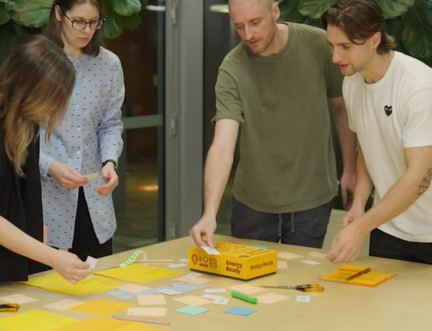 A group of people looks at cards from the Energy Ready Toolkit