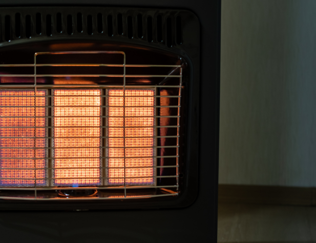 Photo of a gas heater in darkness, illuminated orange