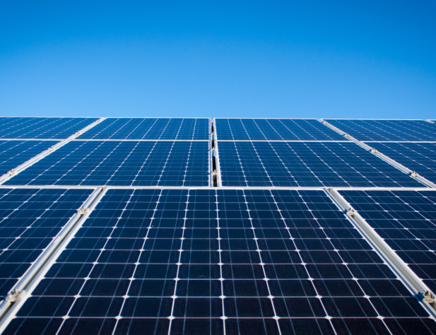 Photo of solar panels against a bright blue sky.