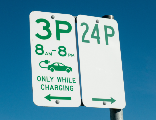 Photo of a parking sign with 3P and 24P written on it, timed hours and a graphic of an electric vehicle with the words 'only while charging'.