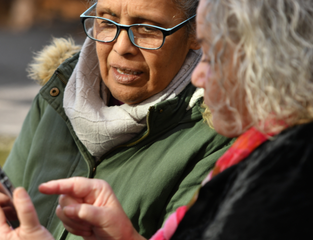 Photo of two people looking at a mobile one. One of them is pointing at it.