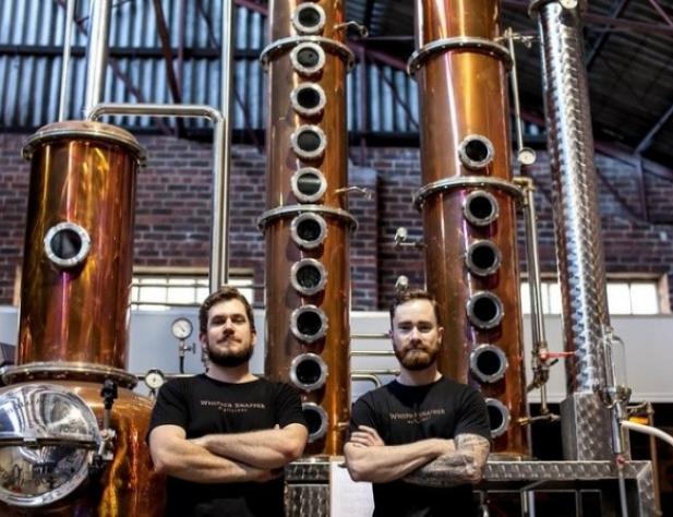 two men standing in front of distilling