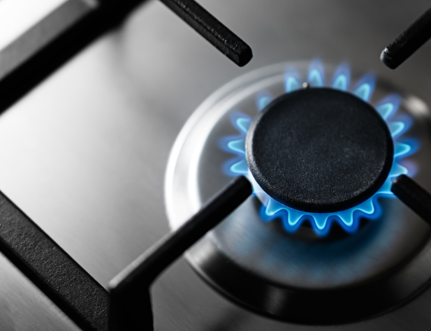 Photo of a gas burner stove with a blue flame and stainless steel surface