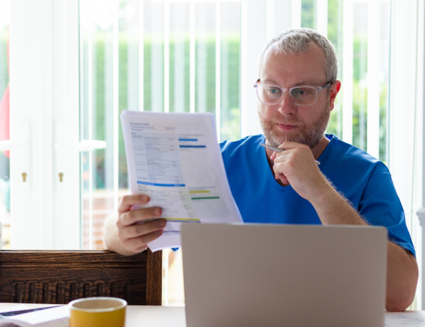 Photo of a person looking at a bill at their desk.