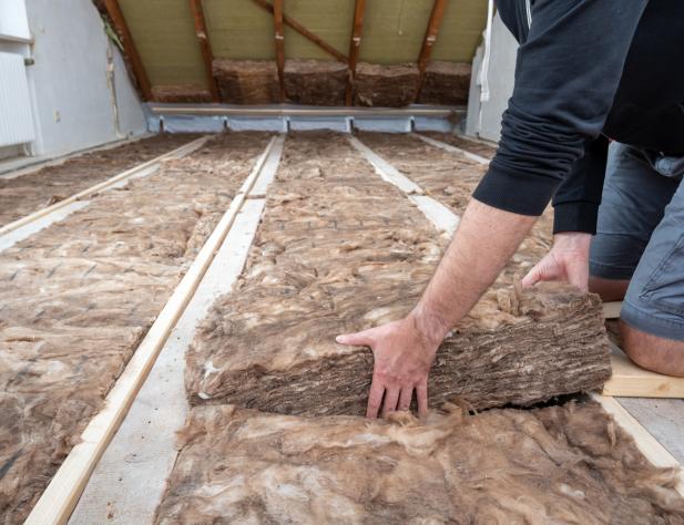 Photo of ceiling insulation being installed in an attic.