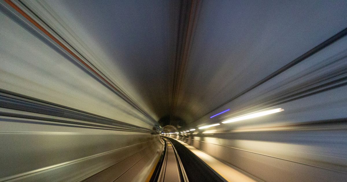 Metro tracks heading into a tunnel with light