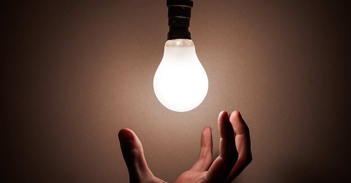 Photo of a light bulb with a hand